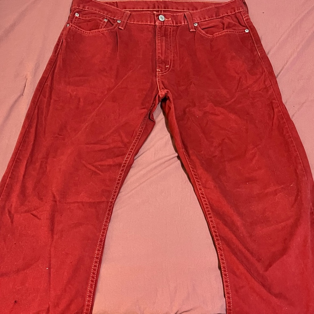 Levi men’s jeans color is a red . The material is a like a soft fabric .